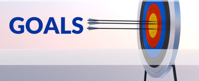 A dart board with the arrows in the Bullseye, with the word GOALS